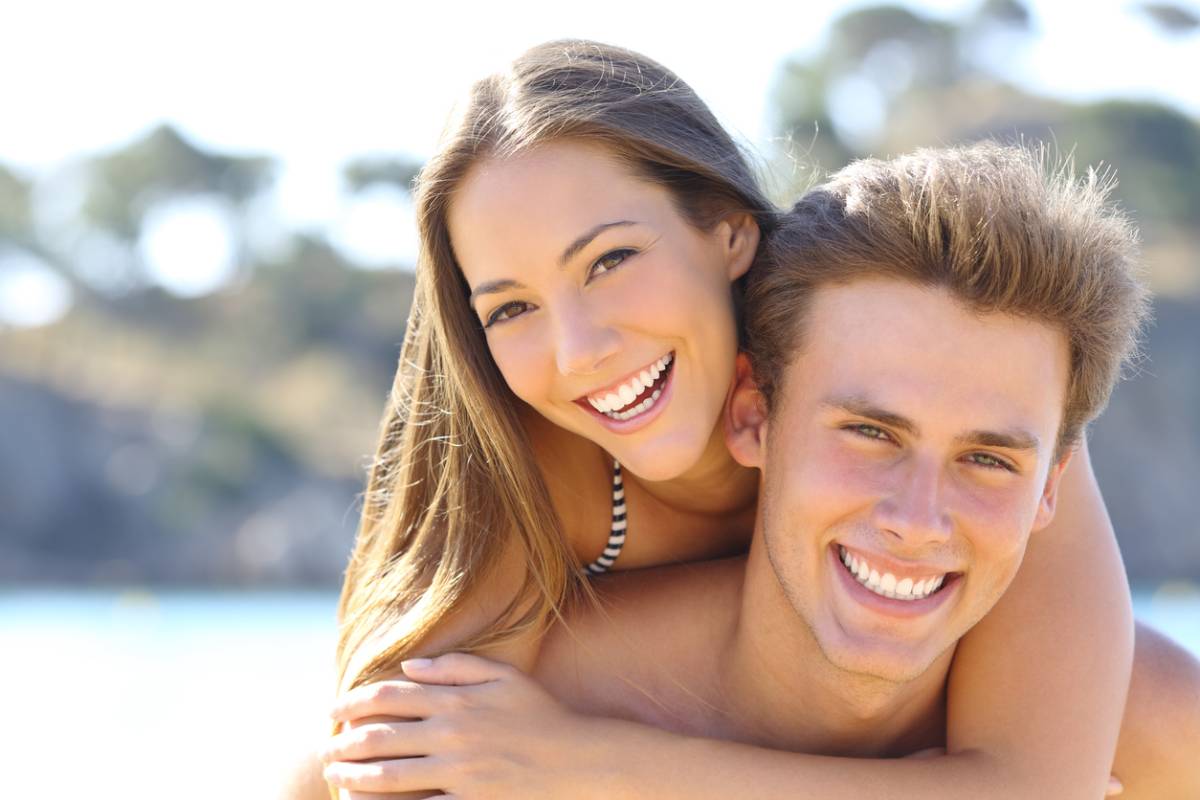 Couple smiling about the health benefits of straight teeth.